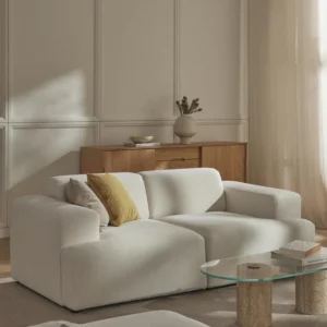 The Melva Sofa (2-Sitzer) offers a refined seating solution for contemporary interiors. Upholstered in soft, textured fabric, it features wide armrests, plush cushions, and a low-profile silhouette that emphasizes both comfort and clean design.