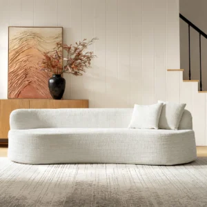 Ivory modern foam sofa with curved design, deep seating, and two matching pillows in a minimalist living space
