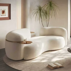 Curved white bouclé 3-seater sofa with sculptural design and built-in gold tray, modern minimalist style.