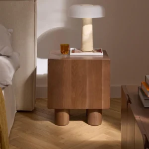 Cadi bedside table made of oak with chunky legs, two compartments, and a soft-close door mechanism