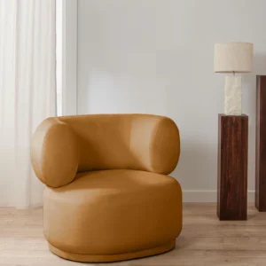 Cori caramel velvet armchair with plush upholstery, reflecting light for varying color tones