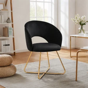Velvet vanity accent chair with curved back, plush seat, and gold metal legs in a modern dressing or living space.
