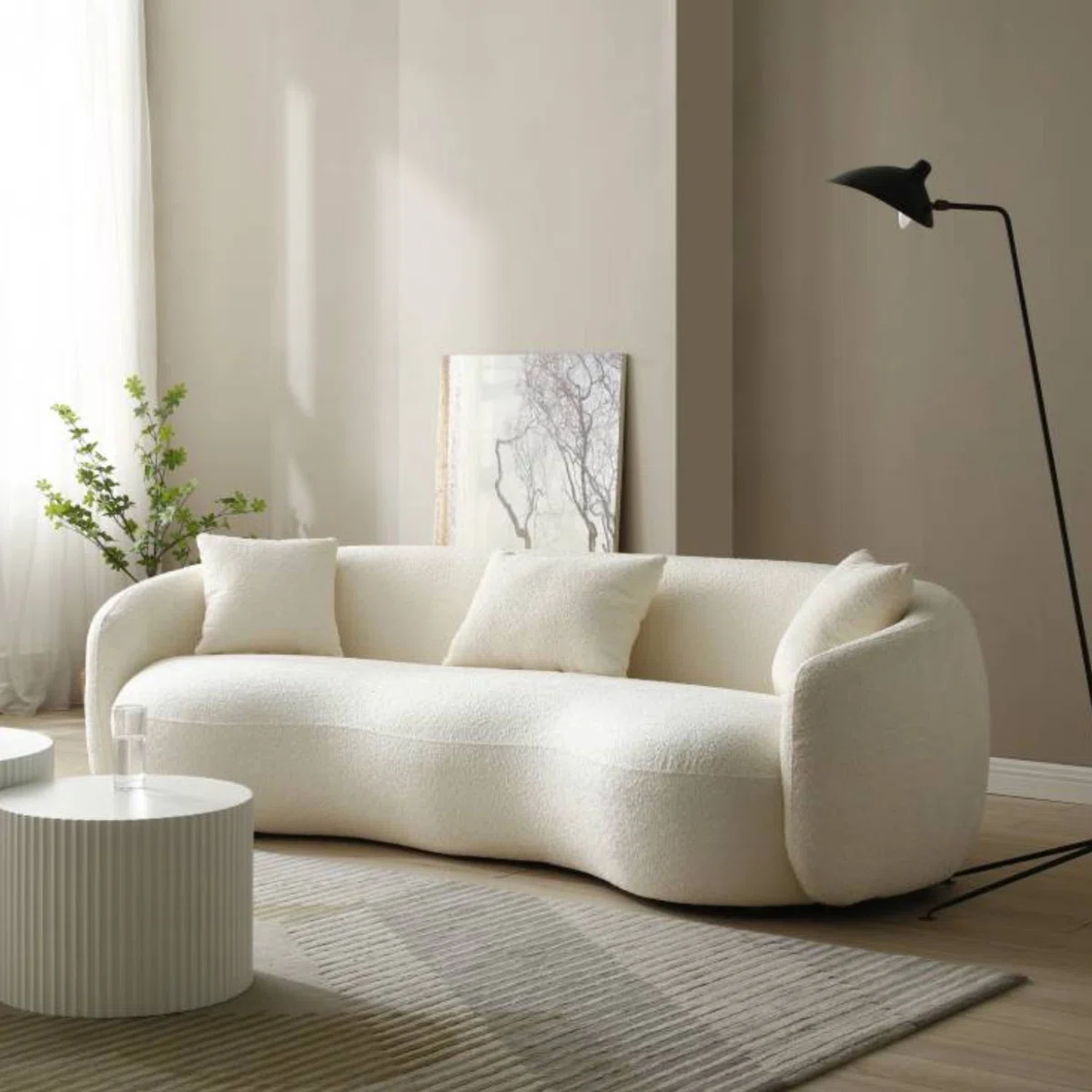 Modern Lumina curved sectional sofa with bouclé upholstery, deep cushioned seating, and storage ottoman in a contemporary living room.
