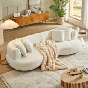 Curved bouclé sectional sofa with deep seating, plush cushions, and four accent pillows in a modern living room setting