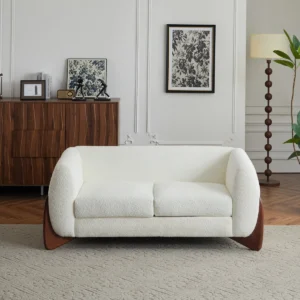 Modern 3-seater bouclé sofa with rounded design, deep cushions, and walnut wood wedge legs.