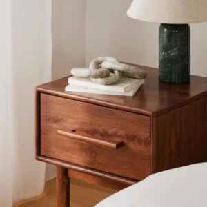 Paul bedside table made of mango wood with dark finish, tapered legs, and one drawer featuring a soft-close mechanism