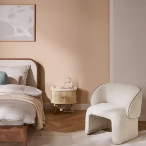 Pina upholstered armchair with rounded shape, curved backrest, and contrasting stitching